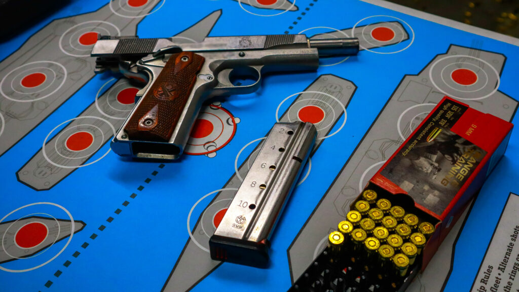 Handgun with ammo on top of shooting target sheet
